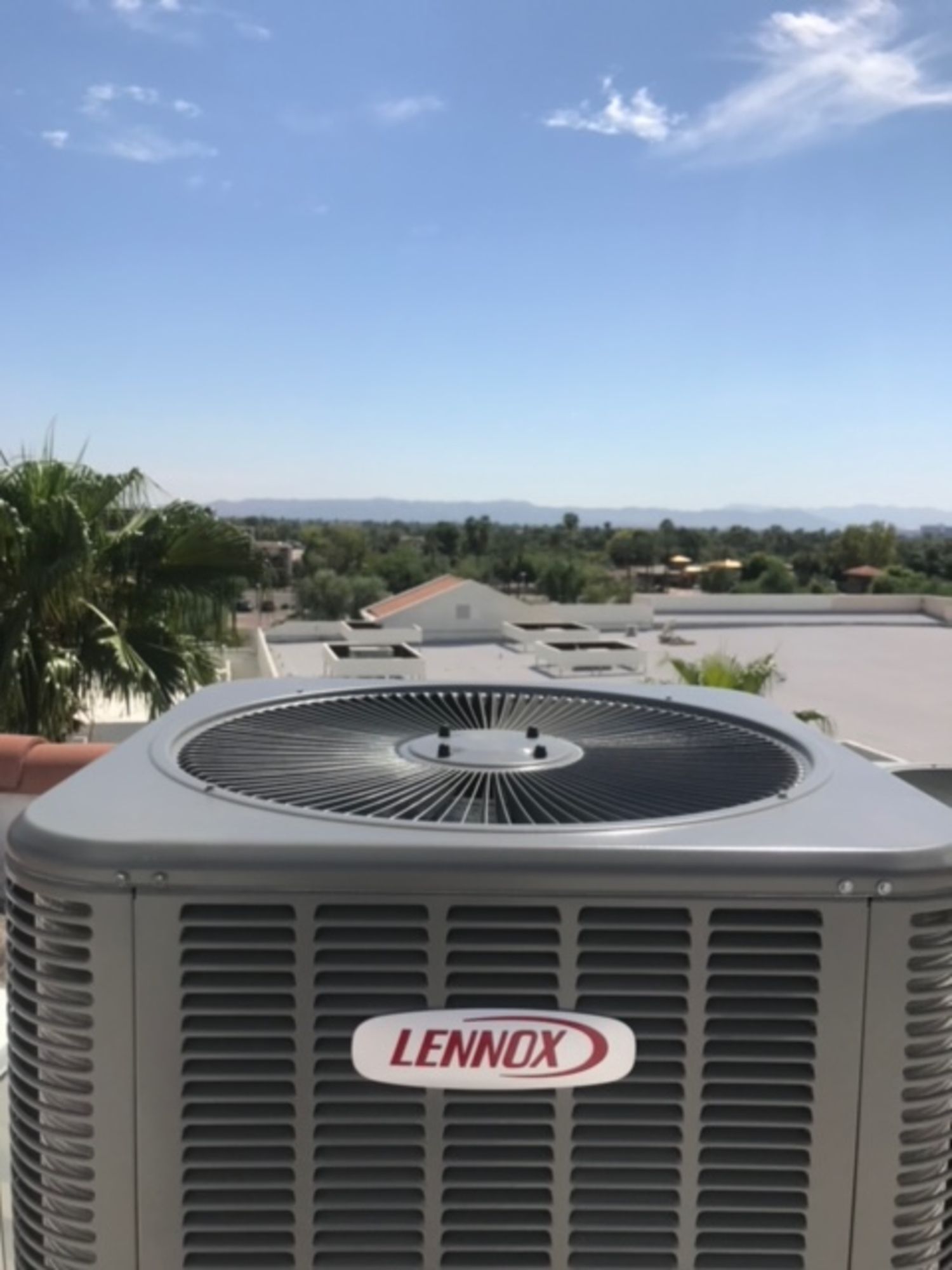 A lennox air conditioner is sitting on top of a roof