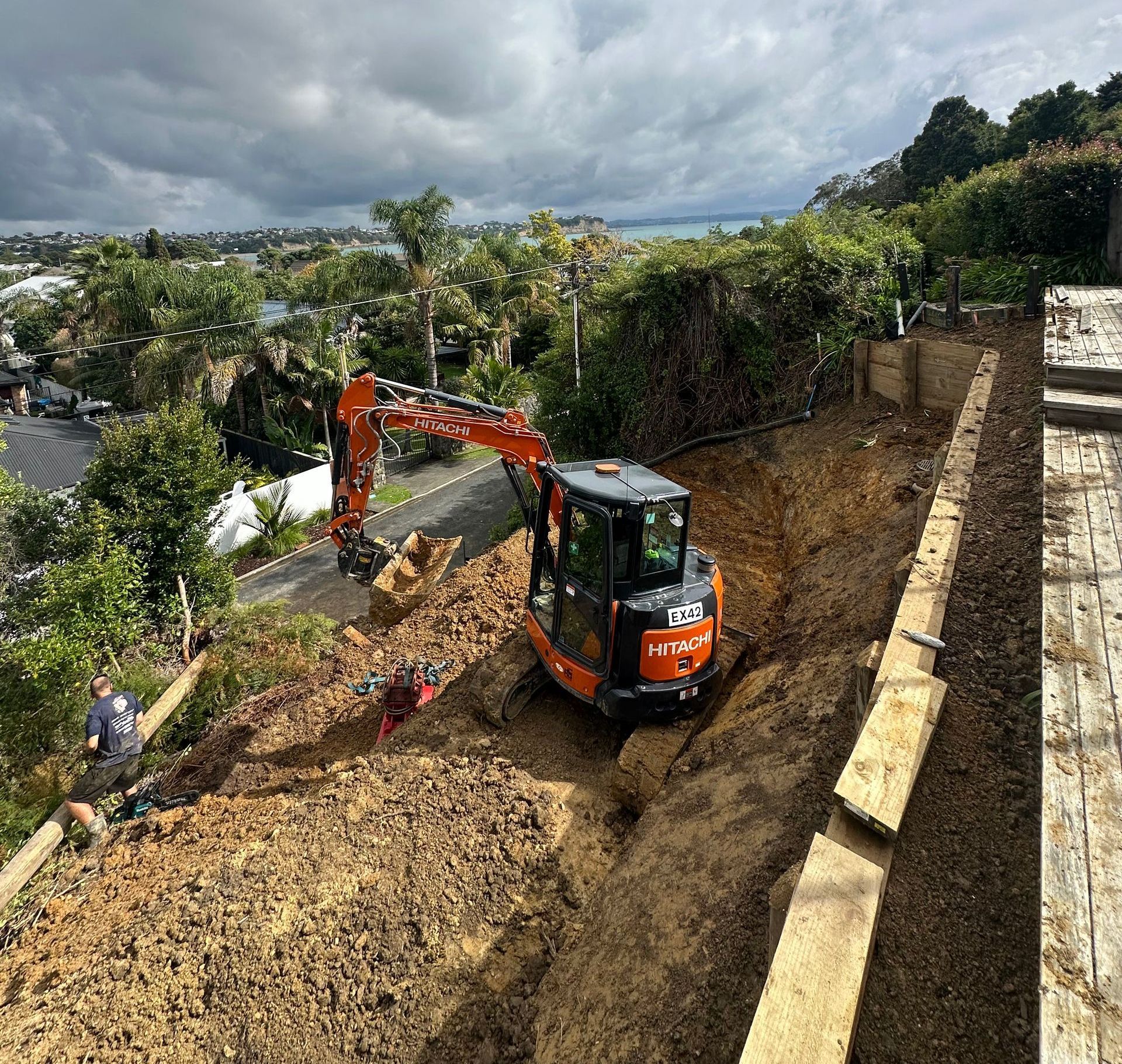 An excavator is digging a hole in the dirt on a hill.