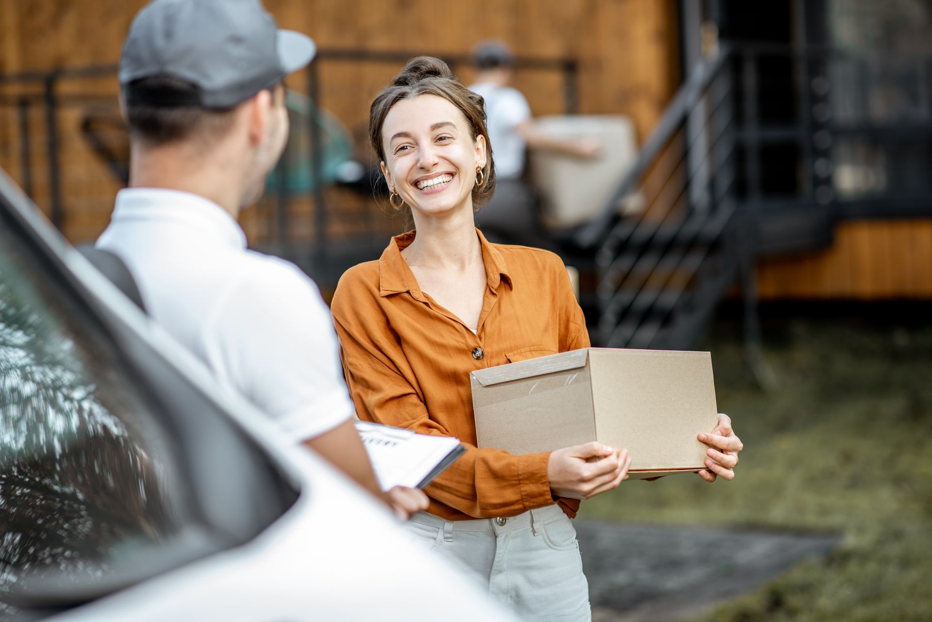 A man is delivering a package to a woman.