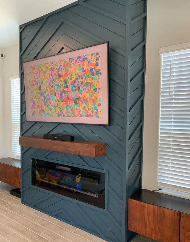 A living room with a fireplace and a flat screen tv on the wall.