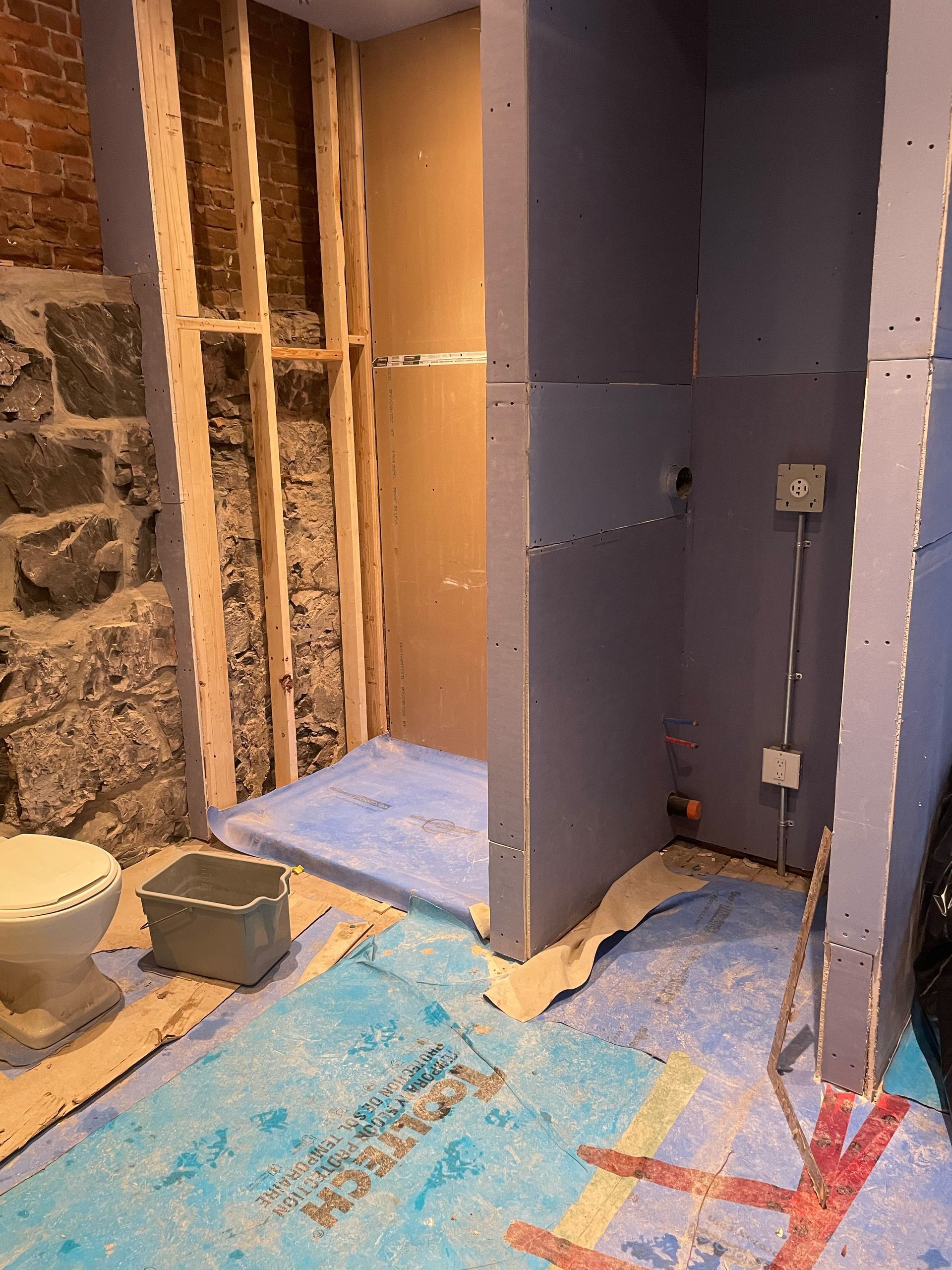 Une salle de bain en construction avec WC et douche.