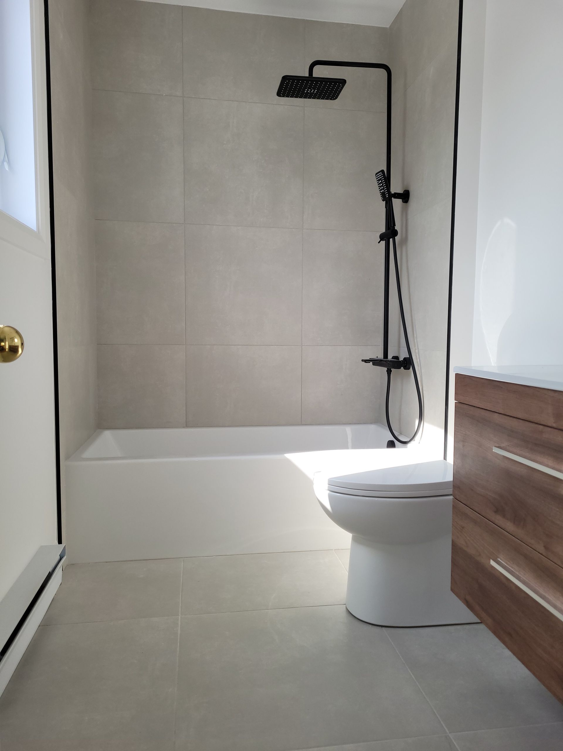 Une salle de bain avec WC , baignoire et douche.