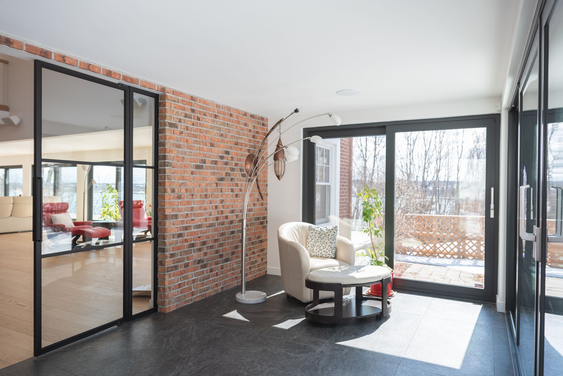 Un salon avec un mur de briques et des portes coulissantes en verre.