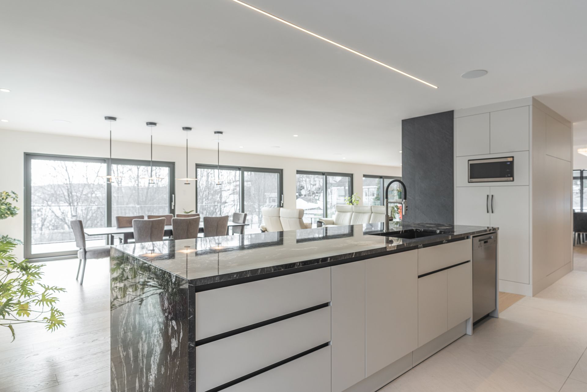 Une cuisine avec un grand îlot au milieu et une salle à manger en arrière-plan.