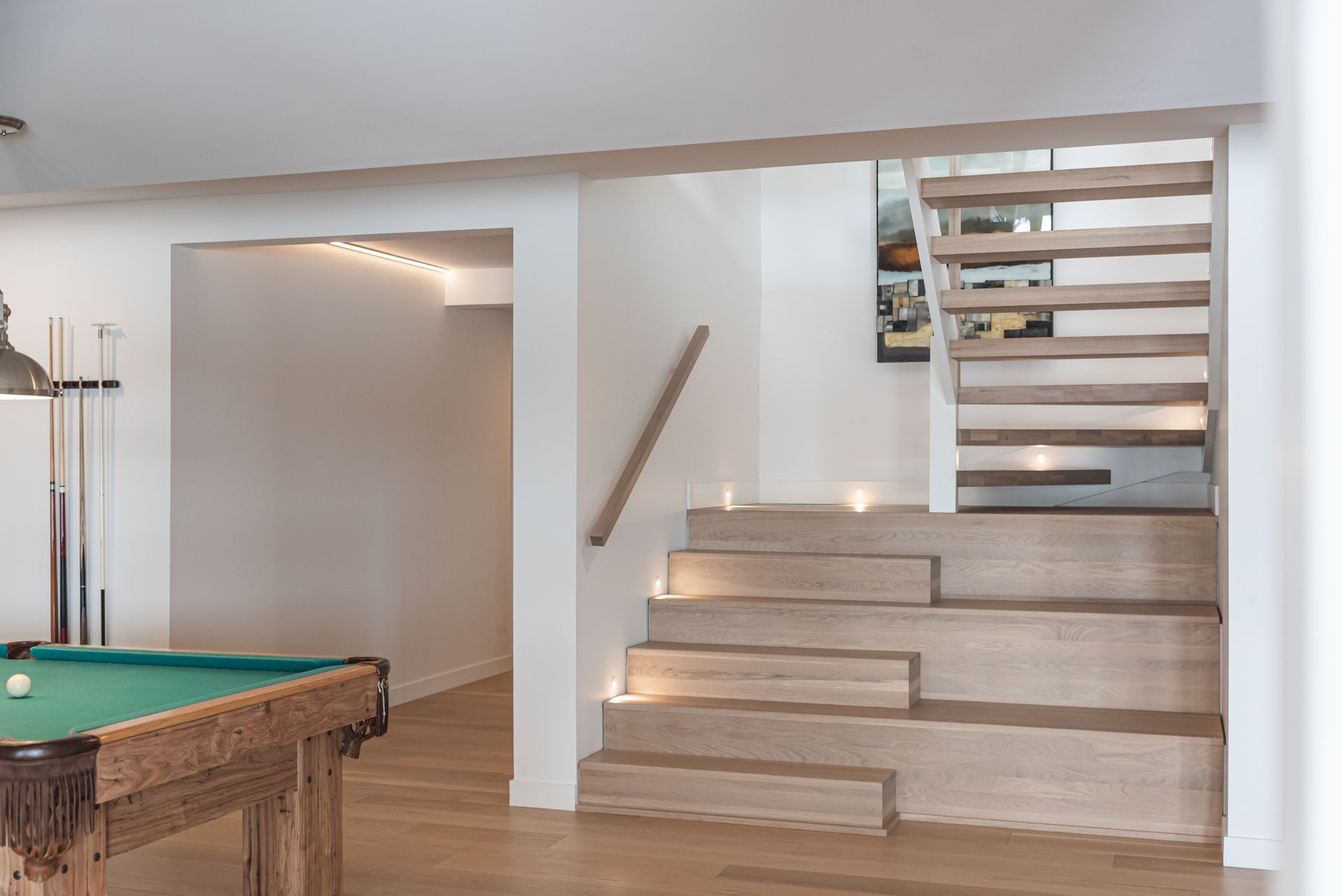Une table de billard se trouve dans une pièce à côté des escaliers.