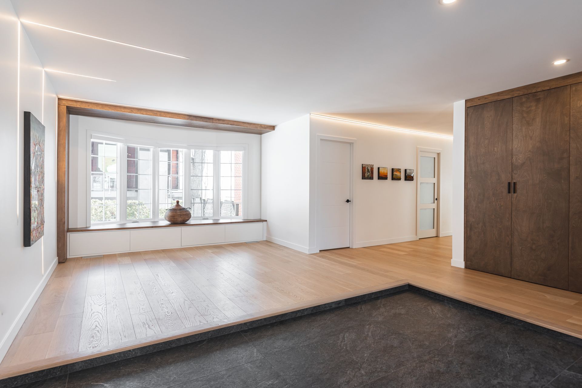 Une grande pièce vide avec beaucoup de fenêtres et du parquet.