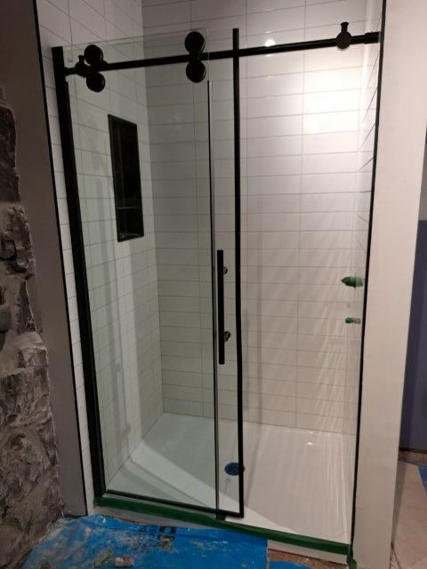 Une salle de bain avec porte de douche coulissante en verre.