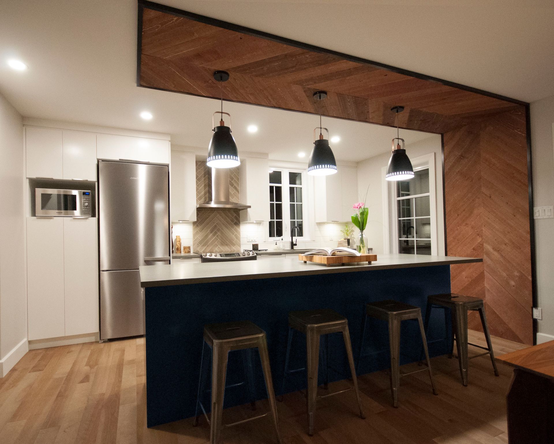 Une cuisine avec un grand îlot et des tabourets