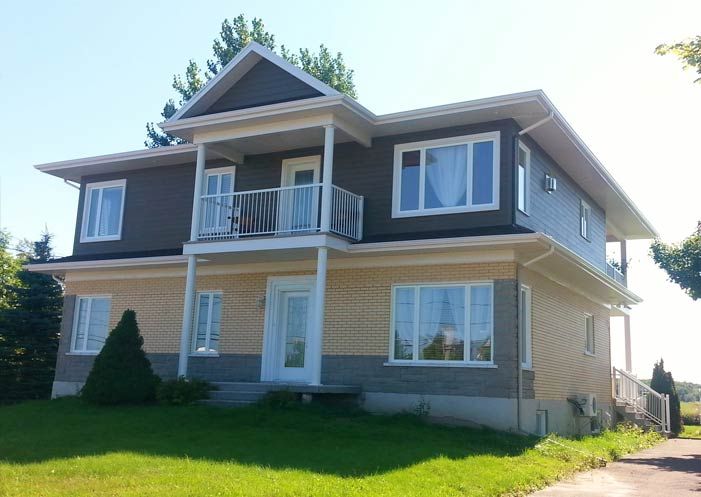 Une grande maison avec un balcon et beaucoup de fenêtres