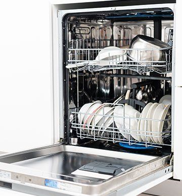 A dishwasher filled with plates , bowls , pots and pans.