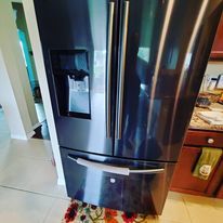 A stainless steel refrigerator is sitting on a rug in a kitchen.