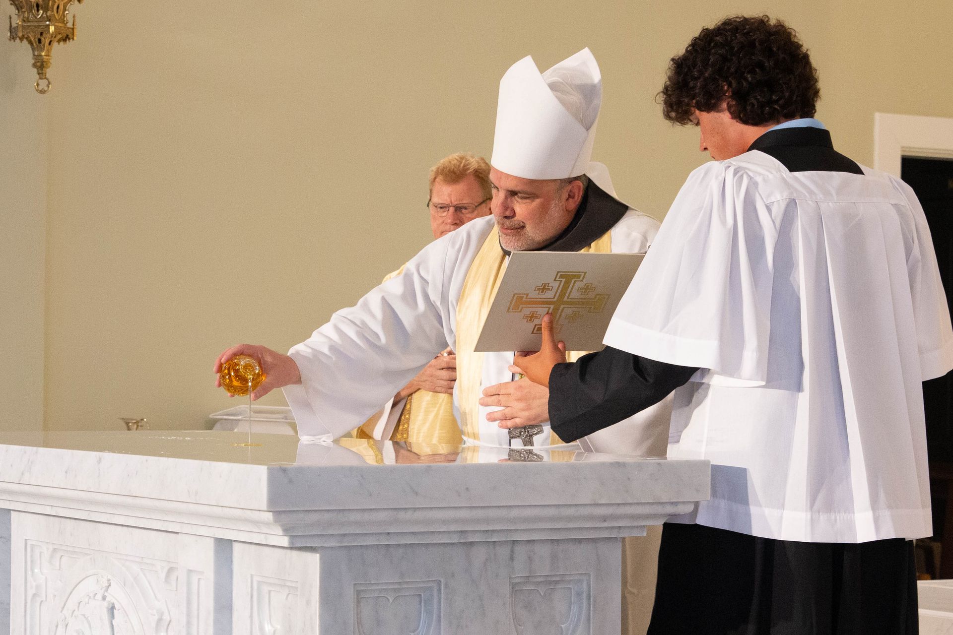 bishop stowe anointing oil on the new altar at st. luke