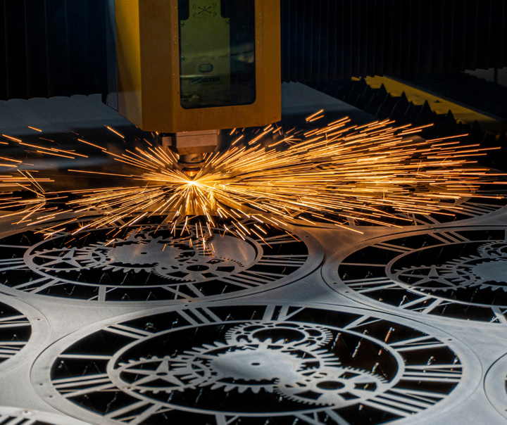 A person is using a machine to cut a piece of metal using laser gases from Metro Welding Supply in Detroit, MI.
