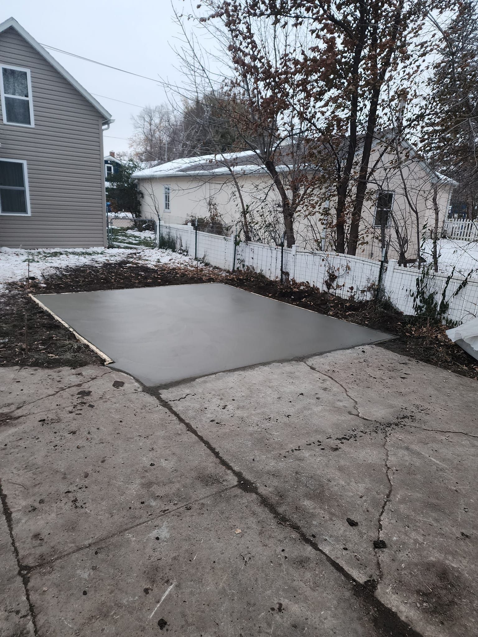A concrete driveway is being built in front of a house.