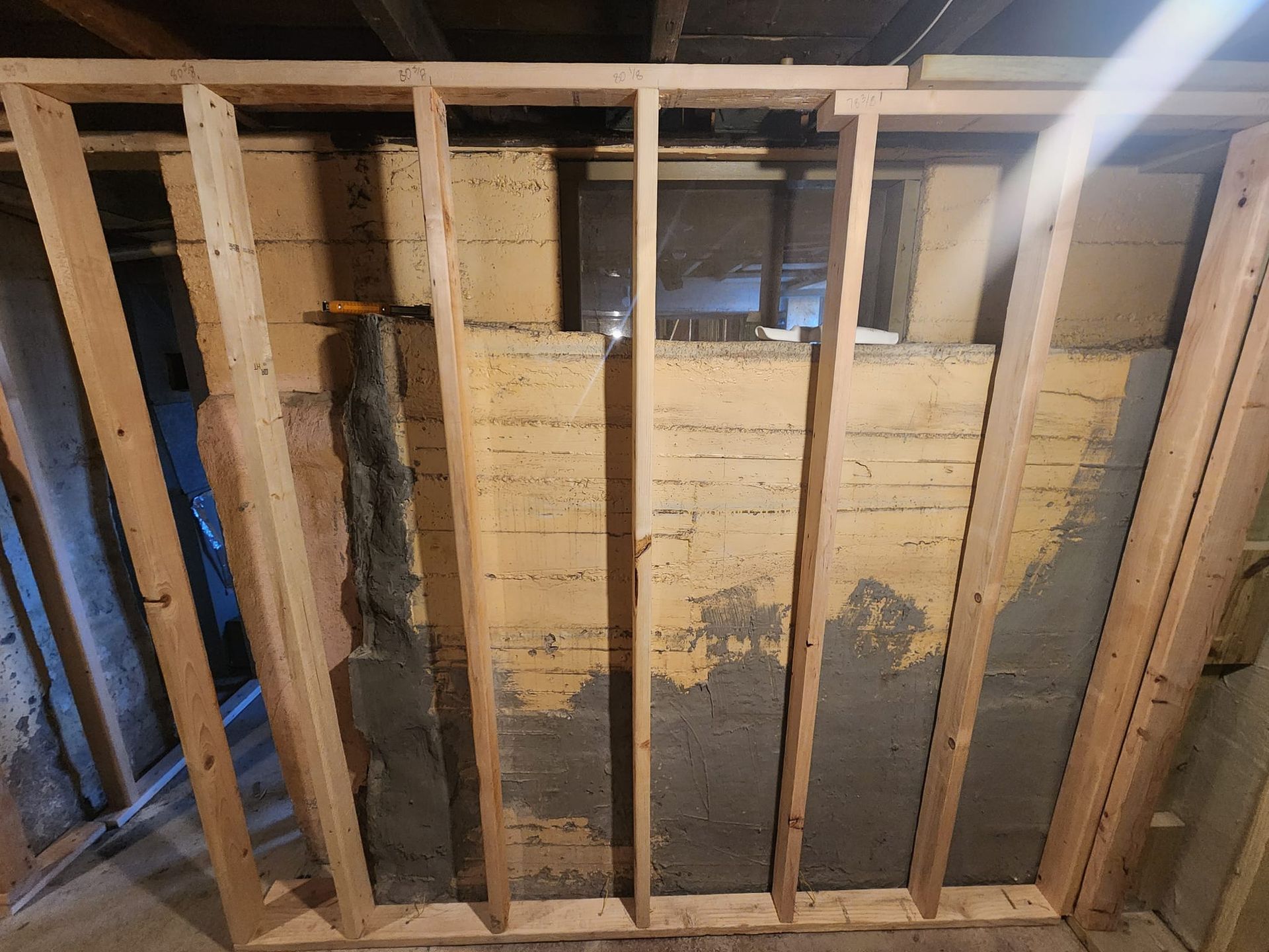 A wooden frame of a wall in a basement