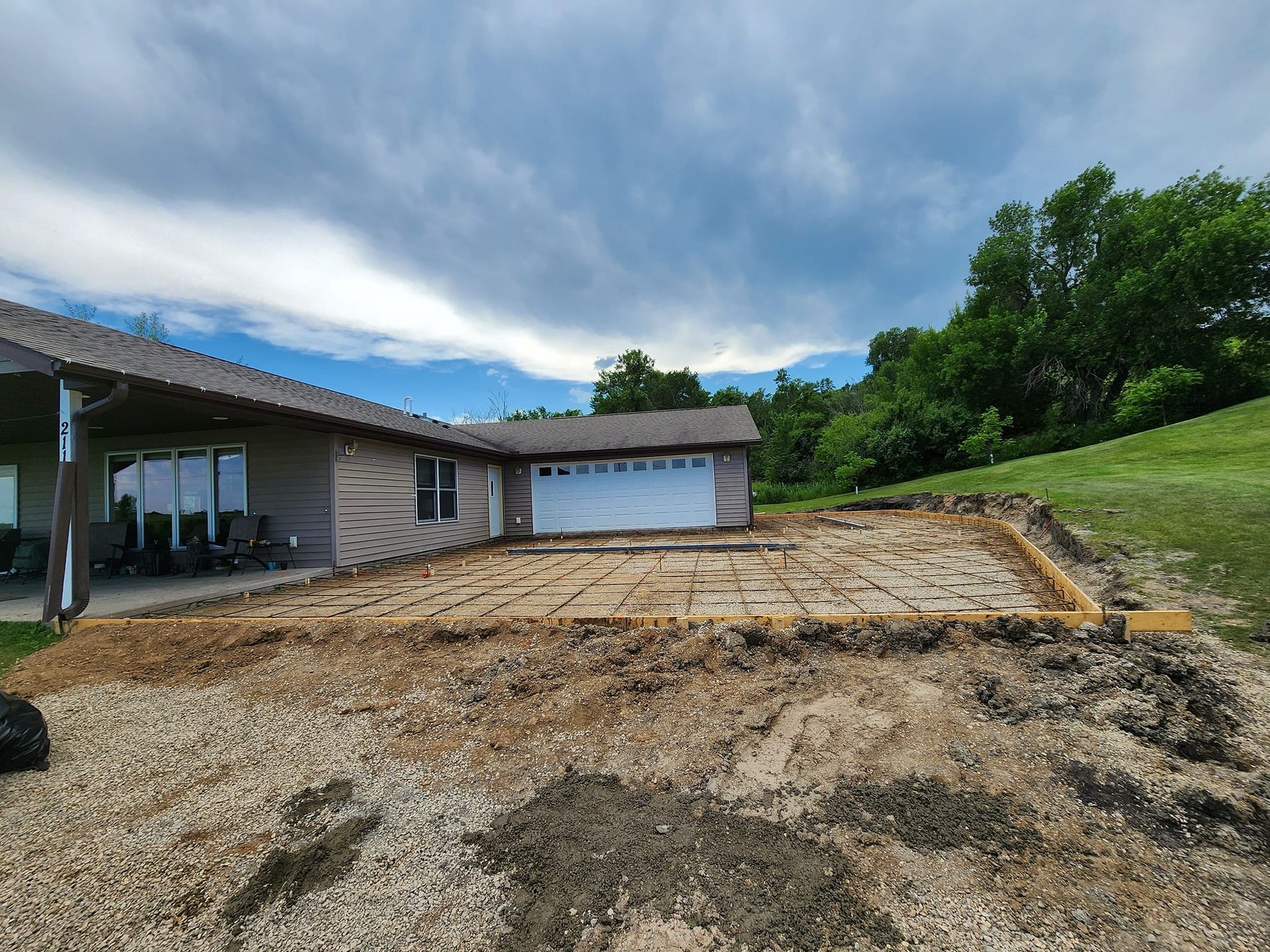 A house with a garage and a lot of dirt in front of it.