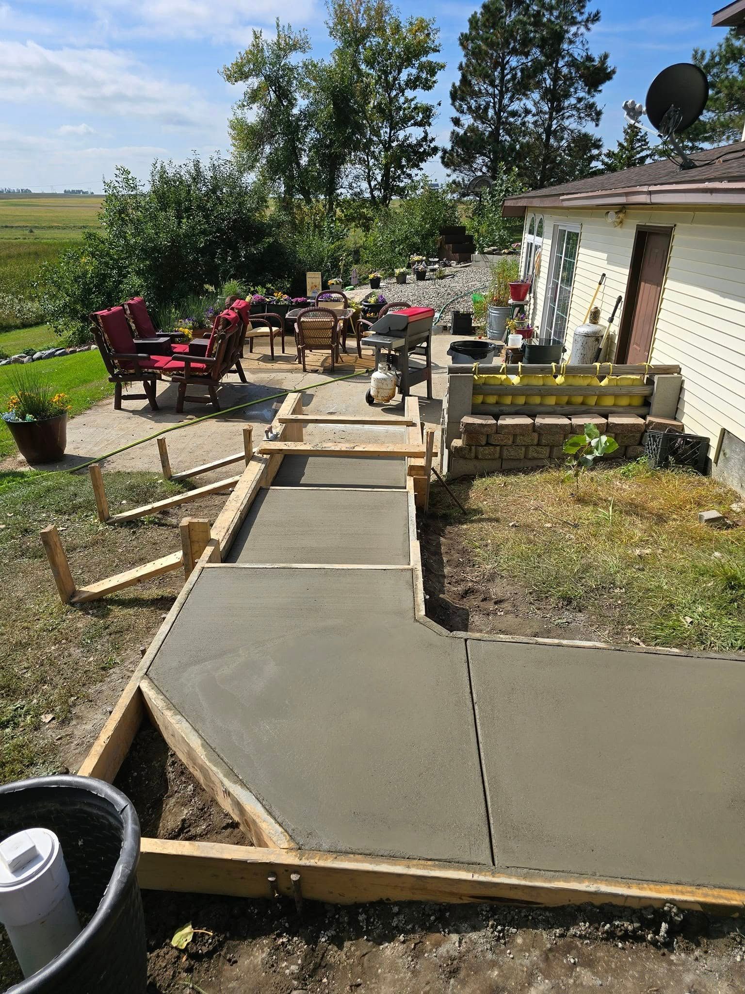 A concrete walkway is being built in front of a house.