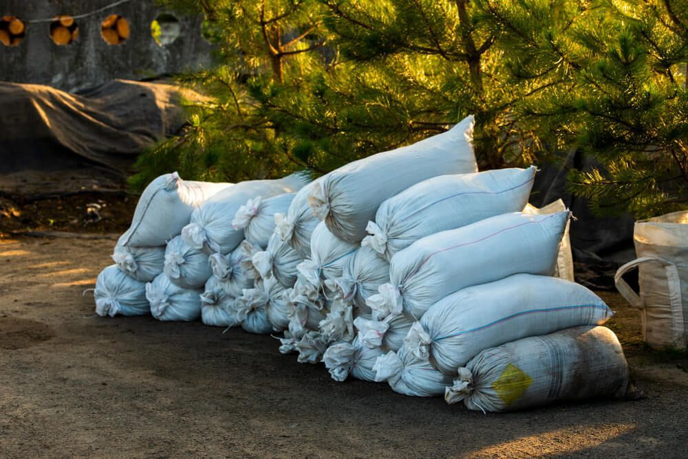 A Pile of Bags Sitting on Top of Each Other on The Ground — Hazells Farm & Fertilizer Services in Taminda, NSW