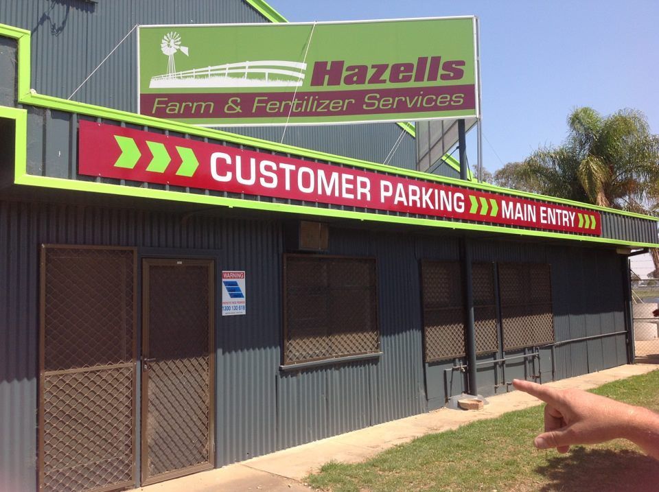 A Stack of Hay Bales in Front of A Building — Hazells Farm & Fertilizer Services in Taminda, NSW