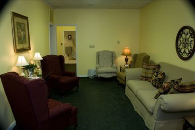 a living room with a couch , chairs and lamps