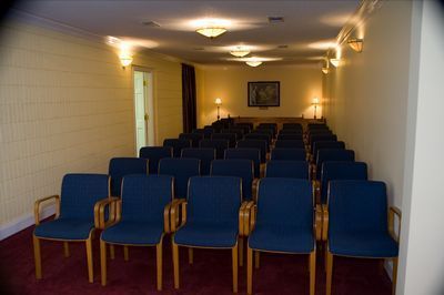 a row of blue chairs are lined up in a room .