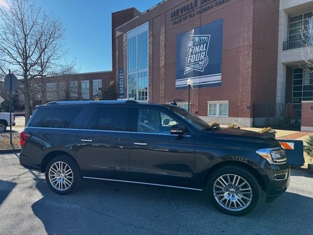 A black suv is parked in front of a building that says reveal