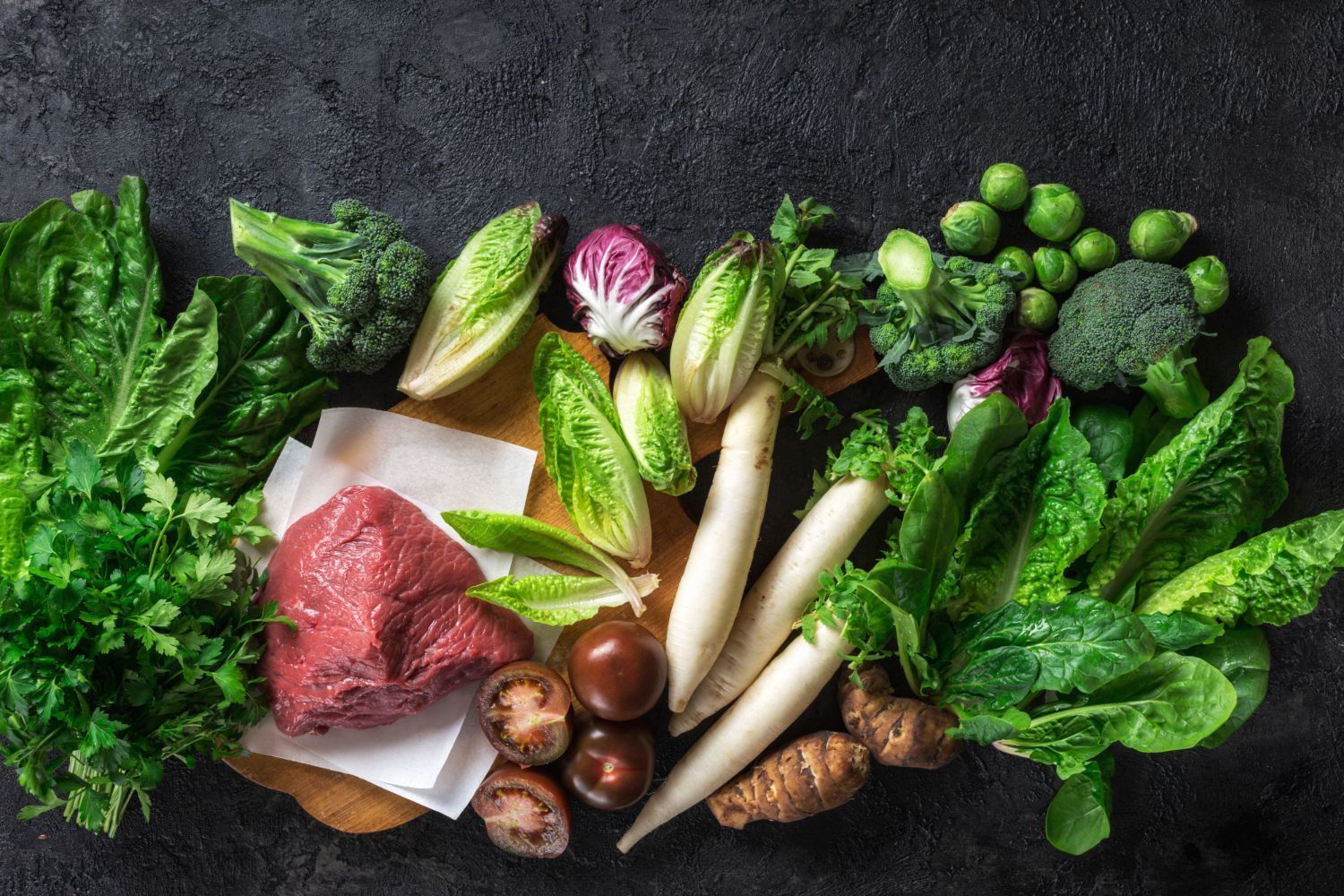 There are many different types of vegetables and meat on the table.
