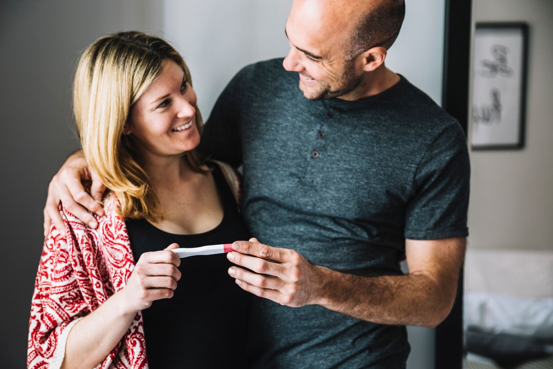 a man and a woman are looking at a pregnancy test