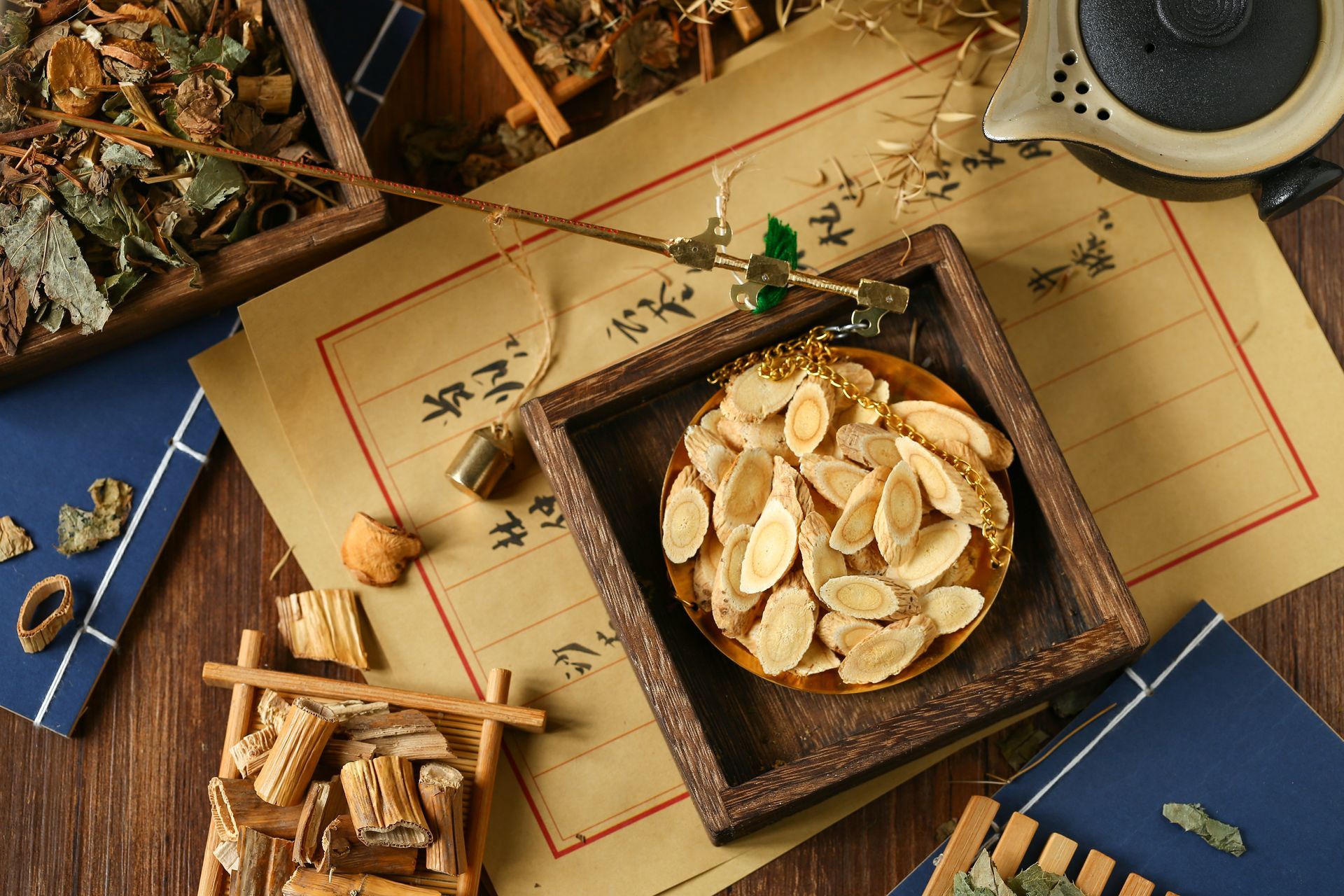 Various dried herbs and medicinal ingredients on parchment paper and wooden trays.