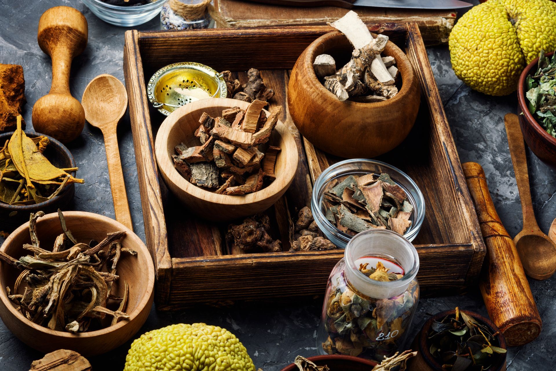 A wooden tray filled with bowls of herbs and spices.