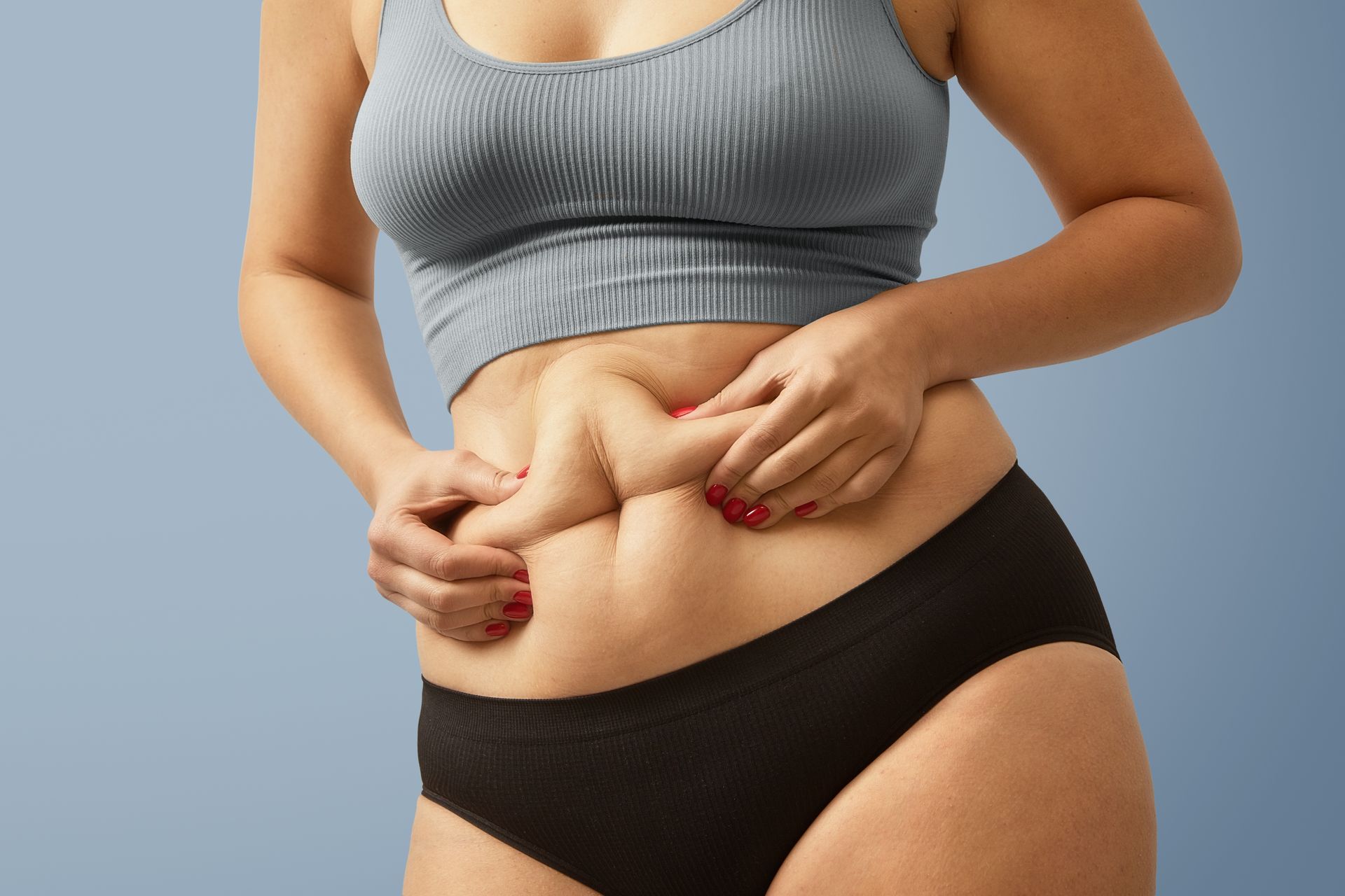 a woman with red nails is holding her stomach