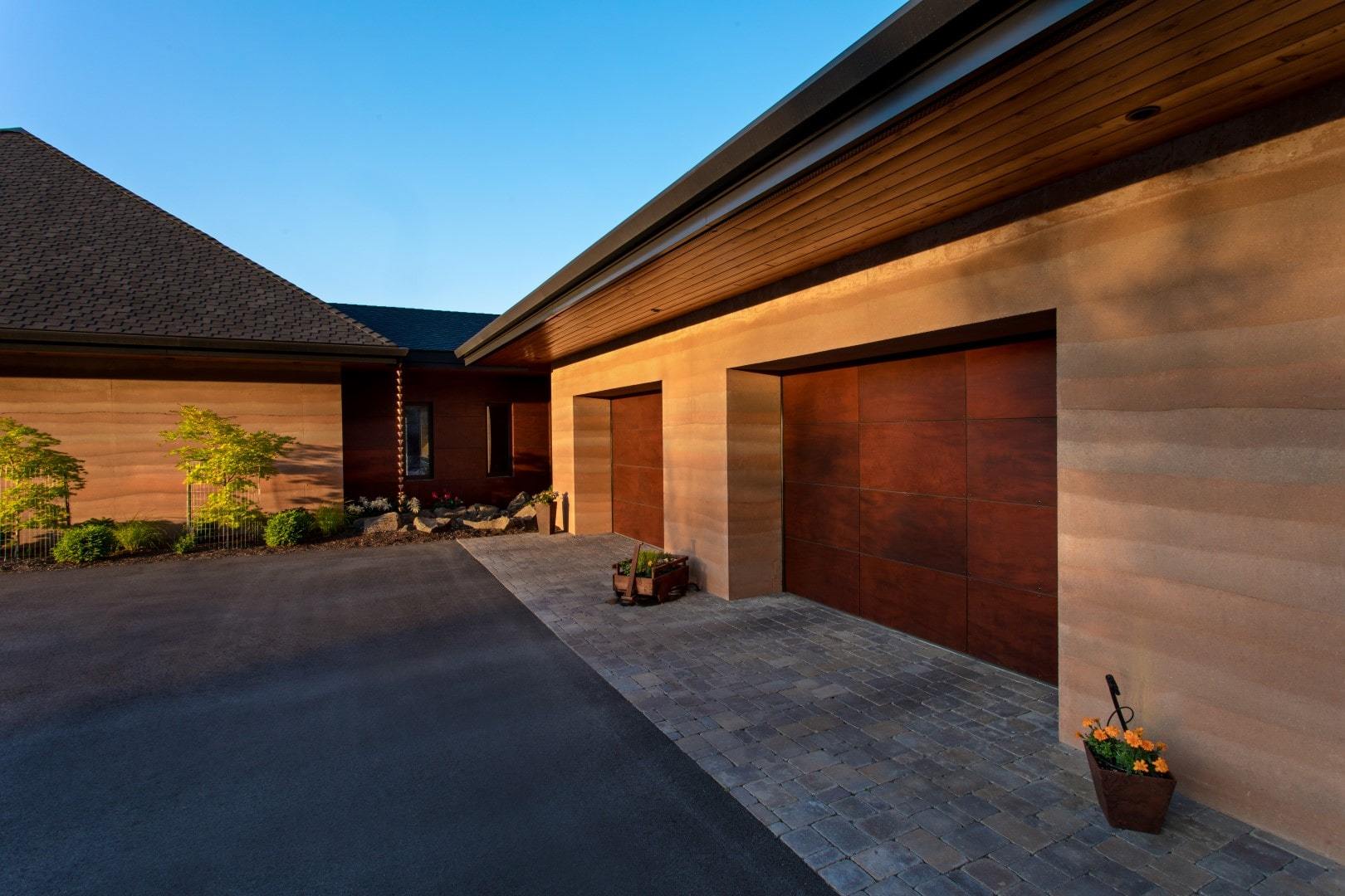 Exterior 2 car garage with rammed earth walls.