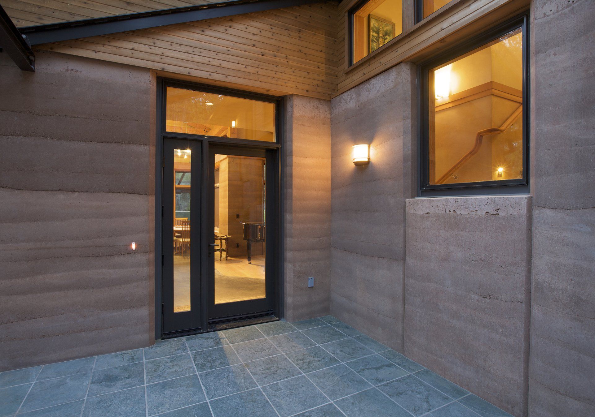 large glass patio door with rammed earth walls