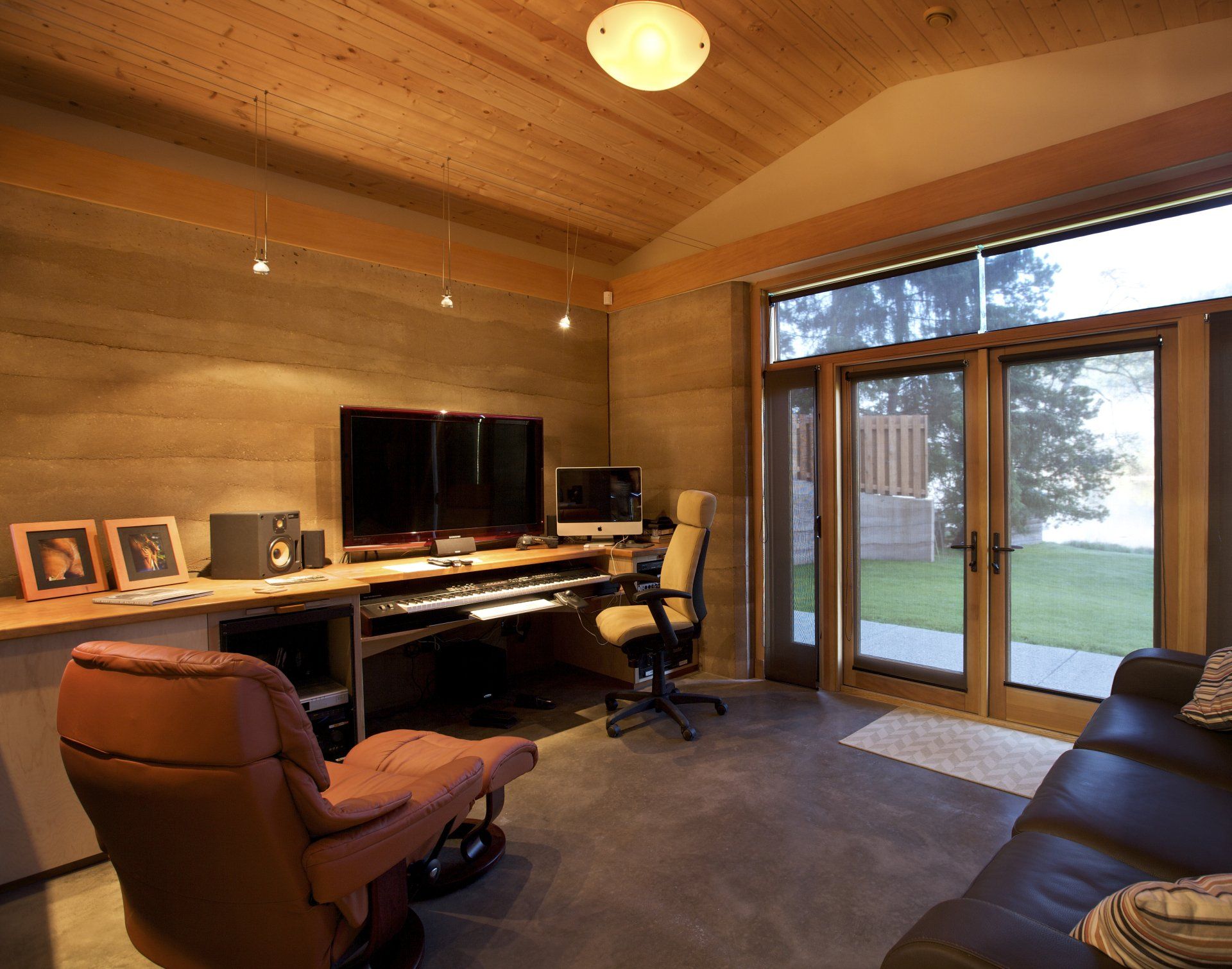 office with rammed earth SIREWALLs and large glass patio door