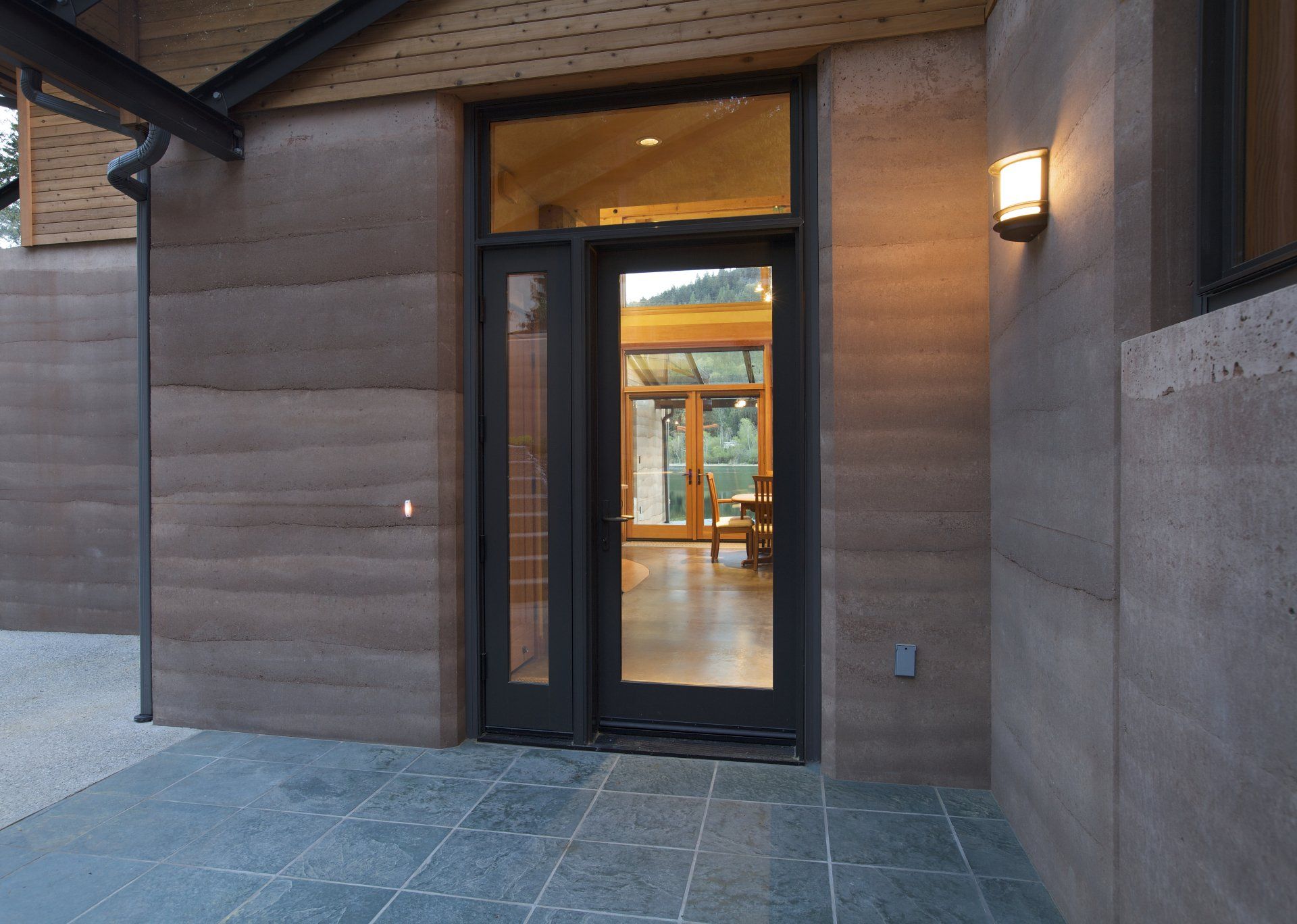 Grierson house front entrance with large glass doors and rammed earth walls
