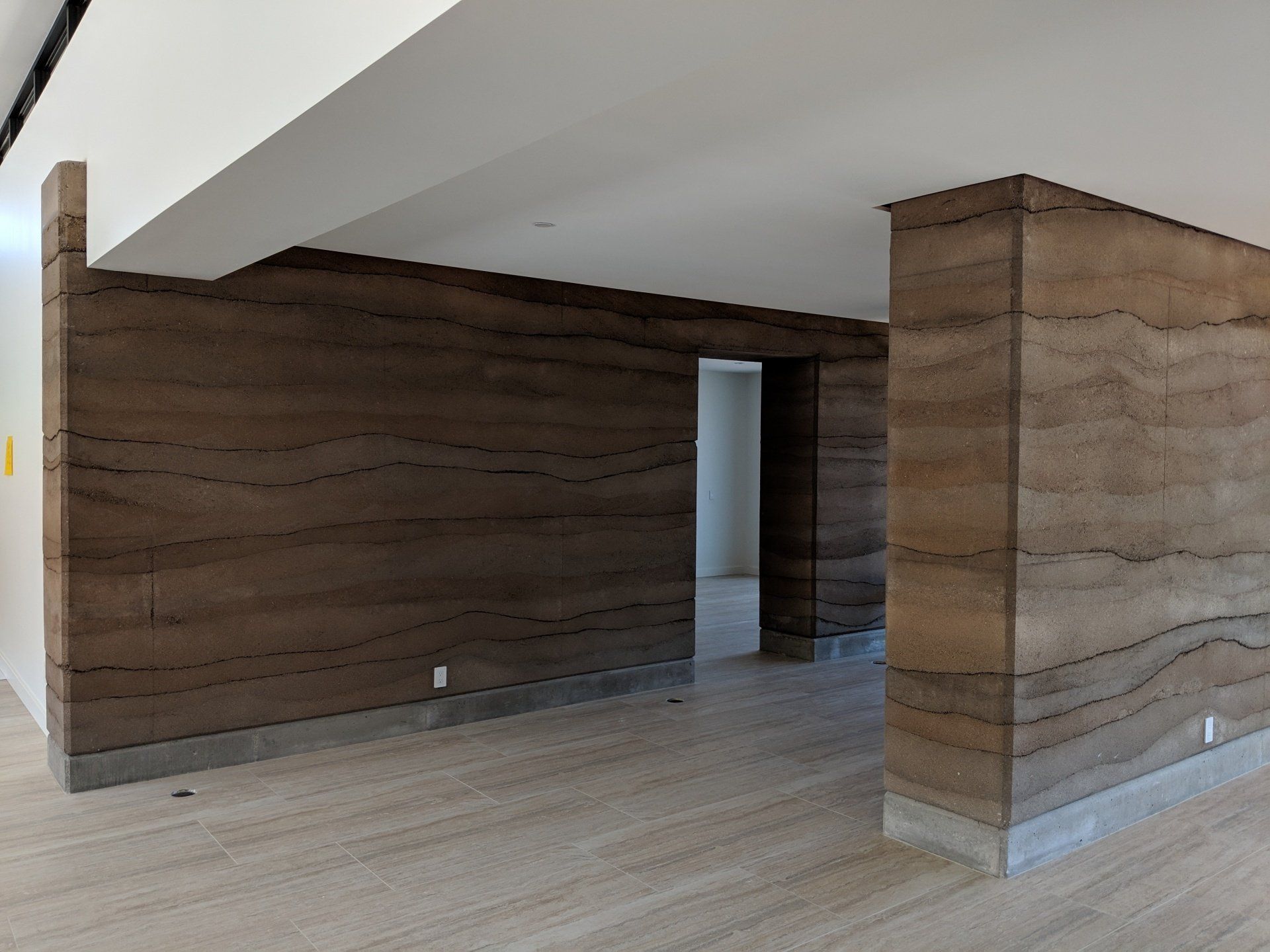 Modern, empty Interior with thick rammed earth walls