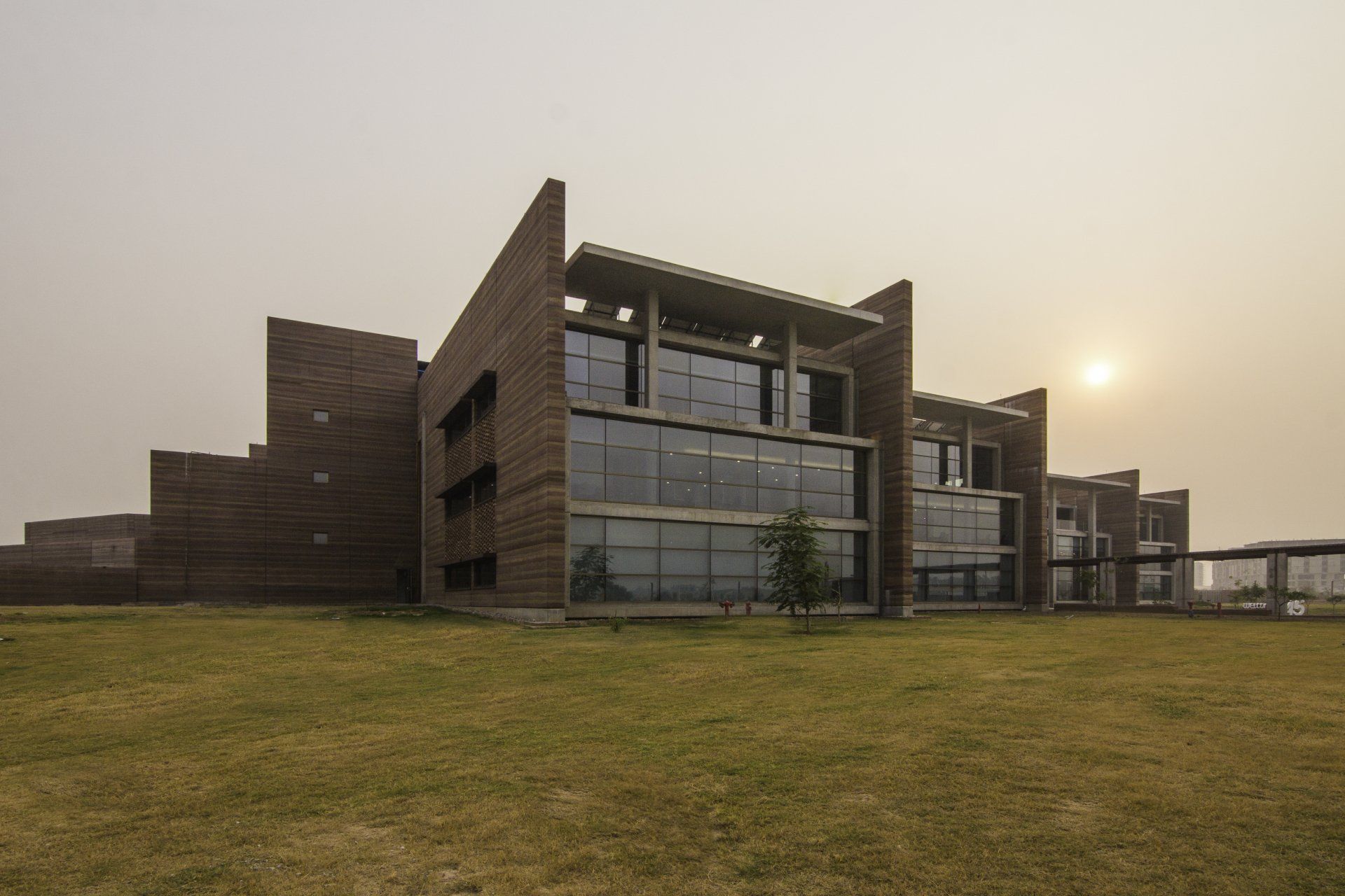 three story rammed earth office building on grassy lawn