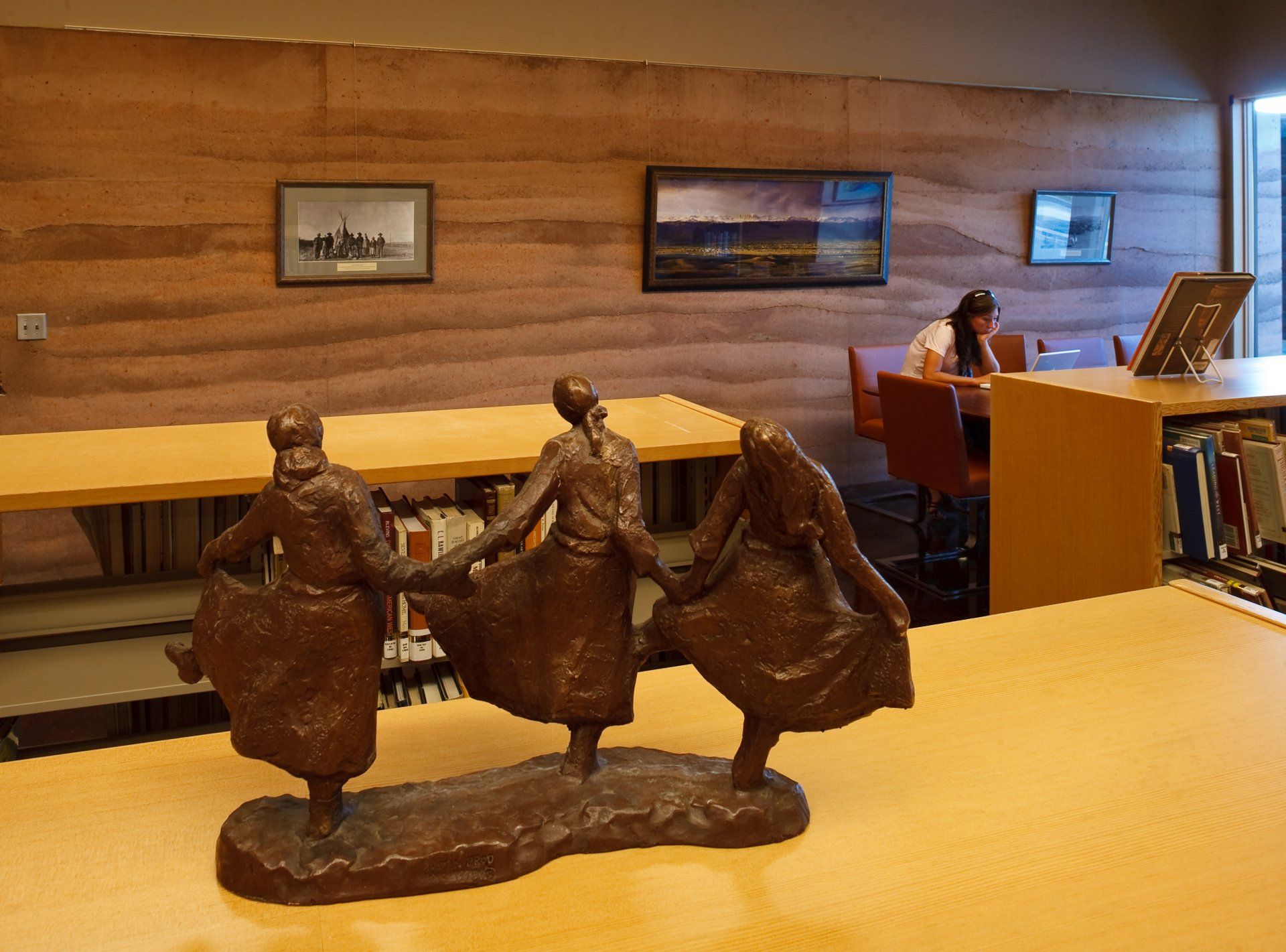 bronze statue of three dancing women  in the sublette county library reading room
