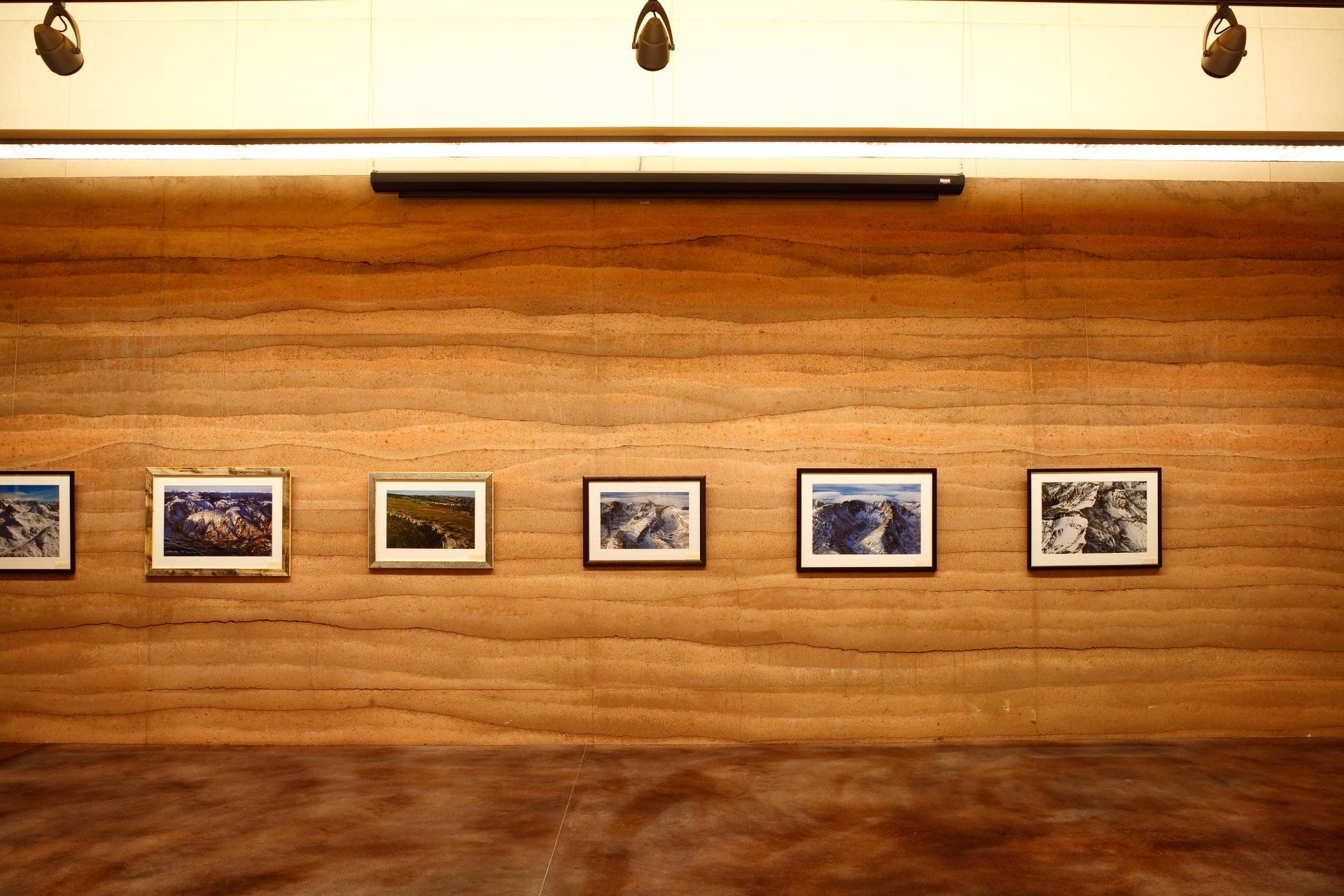 photographs hanging on rammed earth SIREWALL