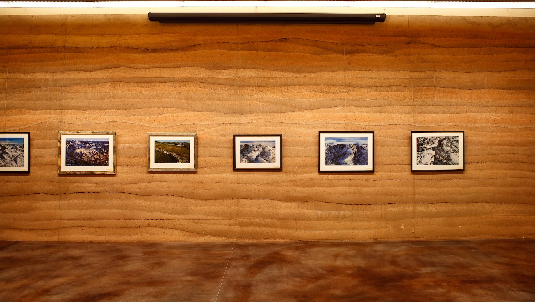 sublette county library rammed earth SIREWALL with photographs hanging like a gallery
