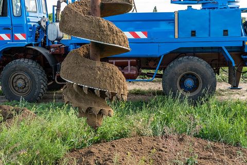 a blue truck is digging a hole in the ground