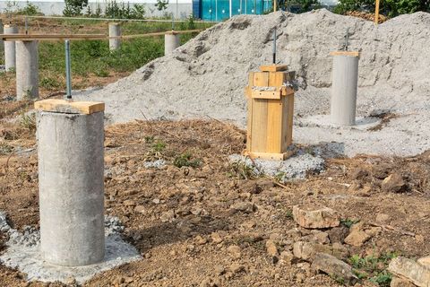 concrete pillars are being built in a dirt field .