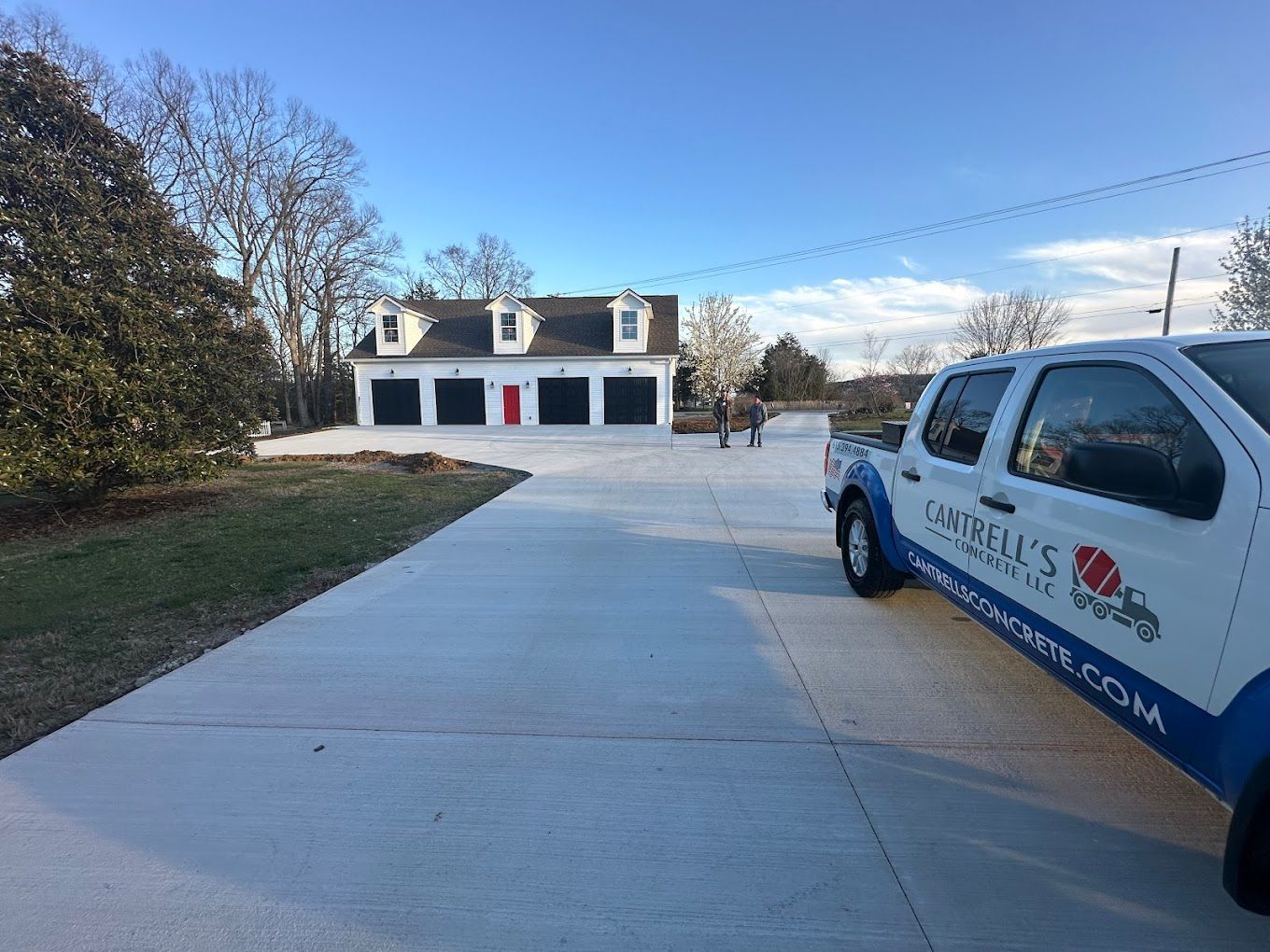 A white truck is parked in a driveway in front of a garage.