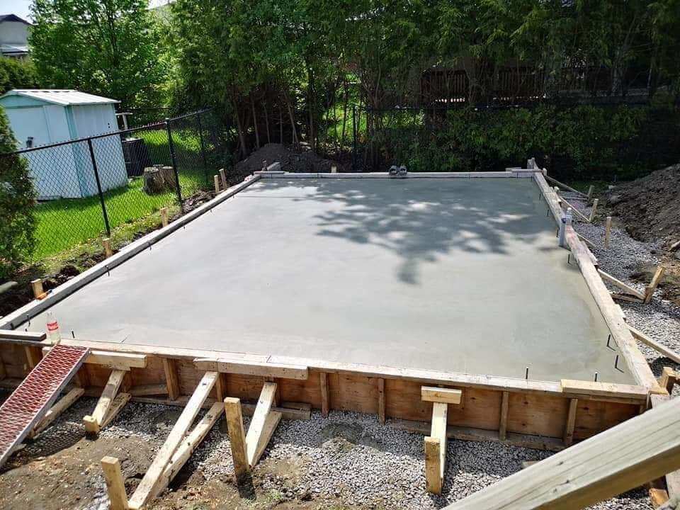 A concrete slab is being built in a backyard.
