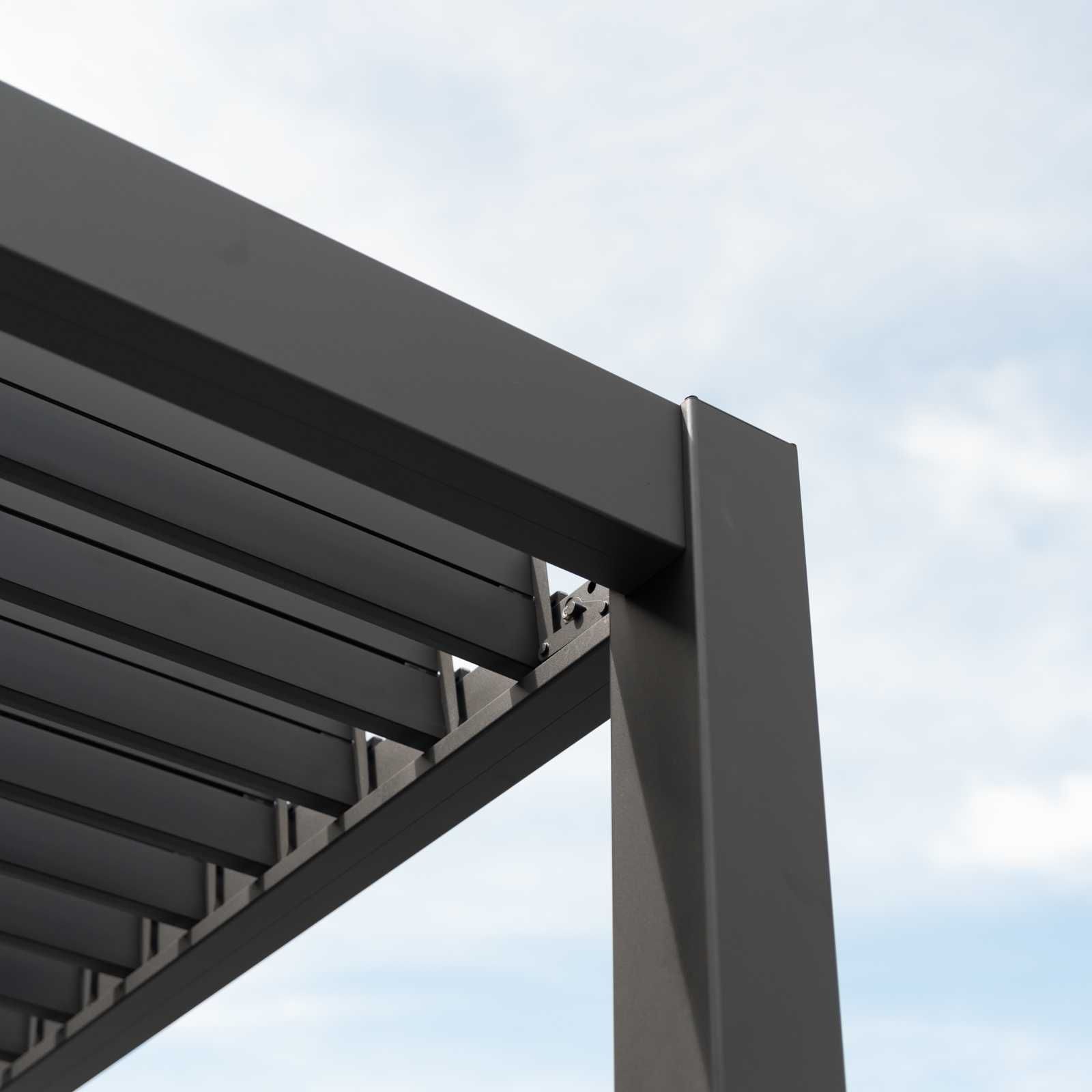 Dark gray metal pergola beams and support post against a cloudy sky