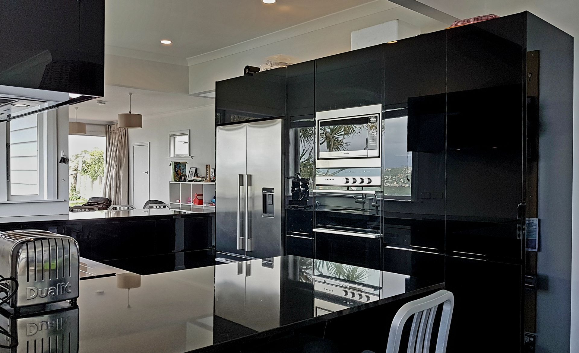 A kitchen with black cabinets and stainless steel appliances