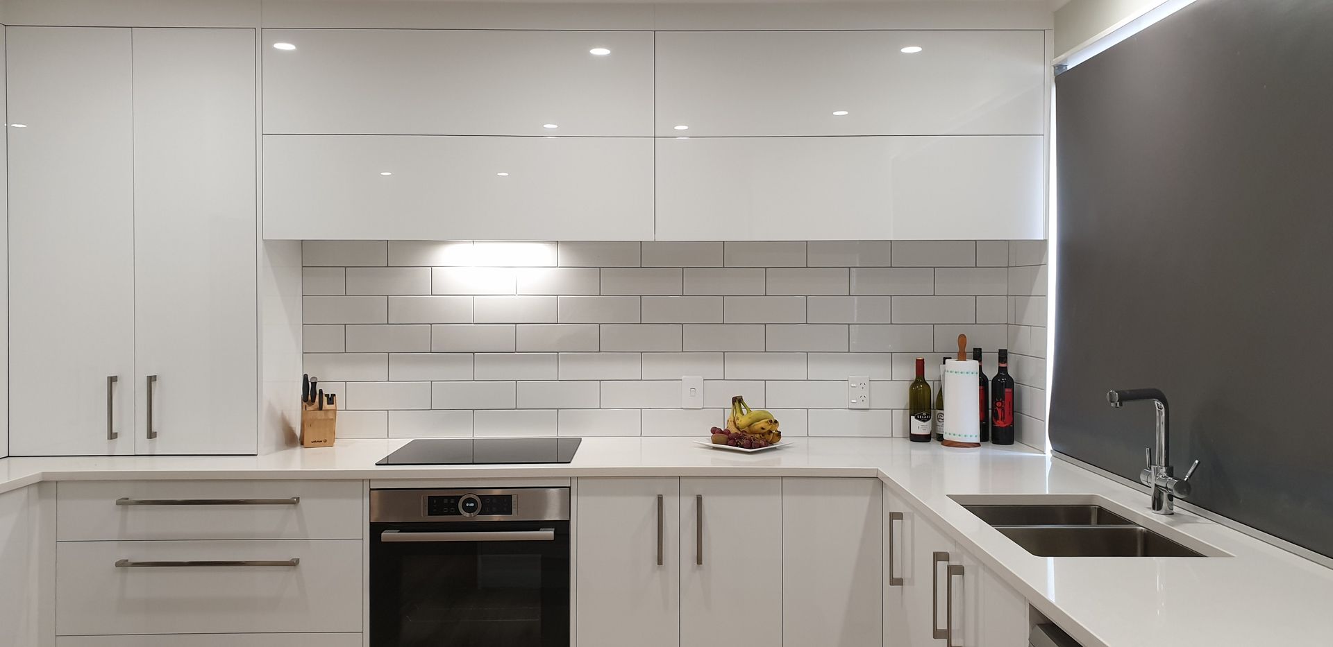 A kitchen with white cabinets , stainless steel appliances , a sink and a stove.