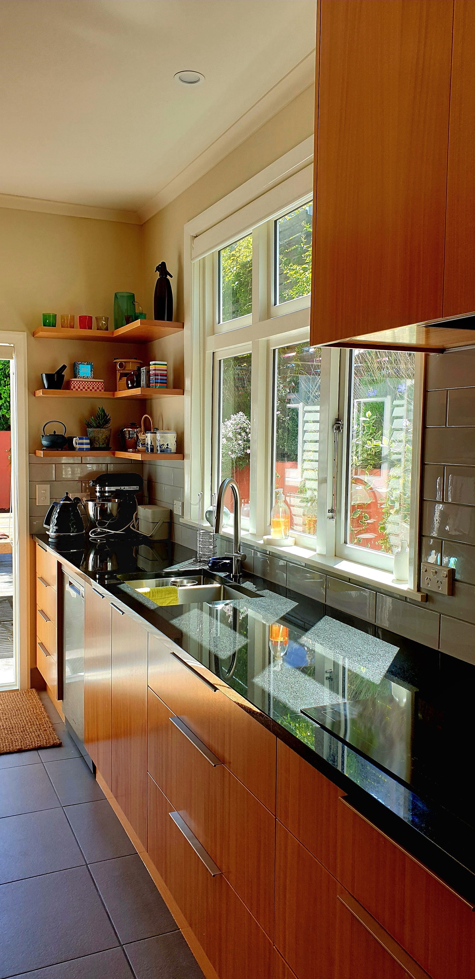 A kitchen with wooden cabinets and black counter tops