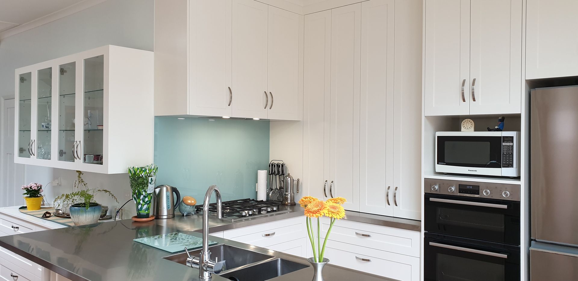 A kitchen with white cabinets and stainless steel appliances