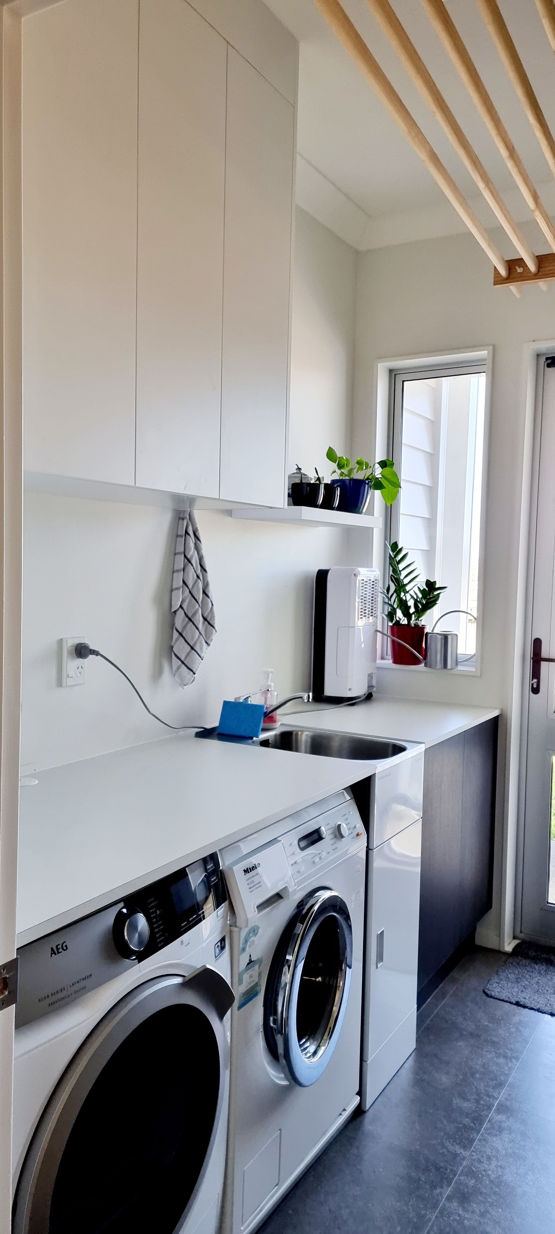 A laundry room with a washer and dryer and a sink.